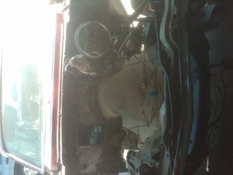 1982 Ford Bronco - The underside of a vehicle is shown, revealing suspension parts and wiring harnesses.