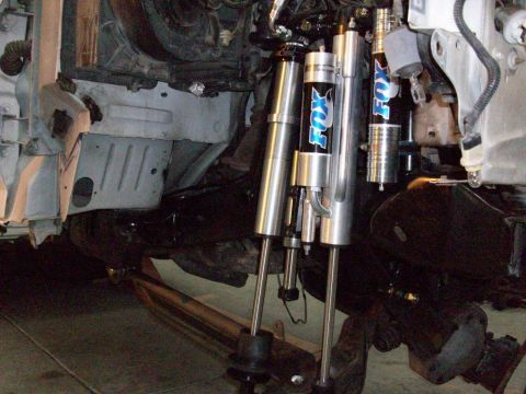 1996 Ford Bronco - Close-up view of aftermarket suspension components, including Fox shocks, installed on a vehicle's chassis.
