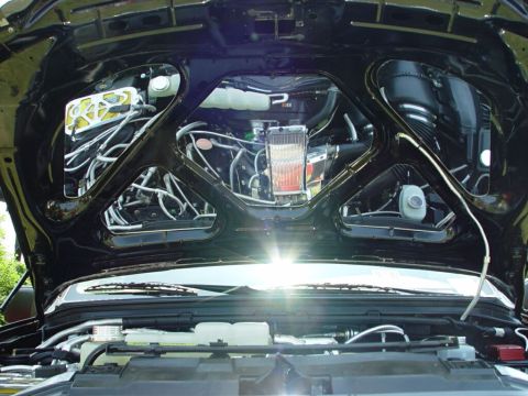 2001 Ford Excursion - The engine bay of a vehicle, a prominent supercharger and intricate wiring, is viewed from above with the hood open.