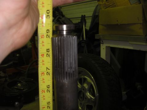 1988 Ford Bronco - A close-up shows a splined shaft being measured with a tape measure, with a tire and wheel visible in the background.