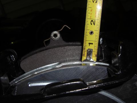 1988 Ford Bronco - Close-up of a vehicle's brake caliper and rotor being measured.