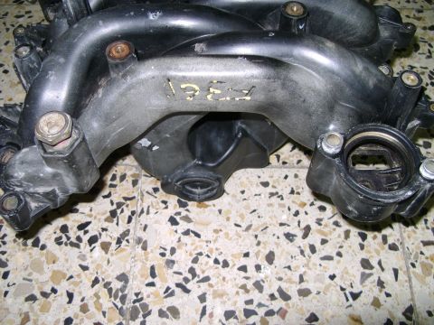 1998 Ford Crown Victoria - A close-up view of a plastic intake manifold with visible yellow markings.