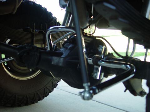 2001 Ford Excursion - Undercarriage view of a rear suspension system with a shiny sway bar.
