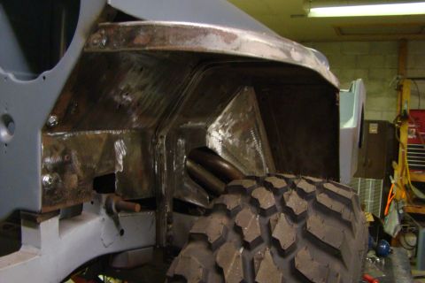 1948 Jeep Wrangler - The interior of a vehicle's wheel well is visible, with exposed metal and a tire in the foreground.