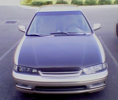 1999 Ford Taurus - This car, possibly a Honda Accord from the mid-1990s, is shown from the front in a parking lot.