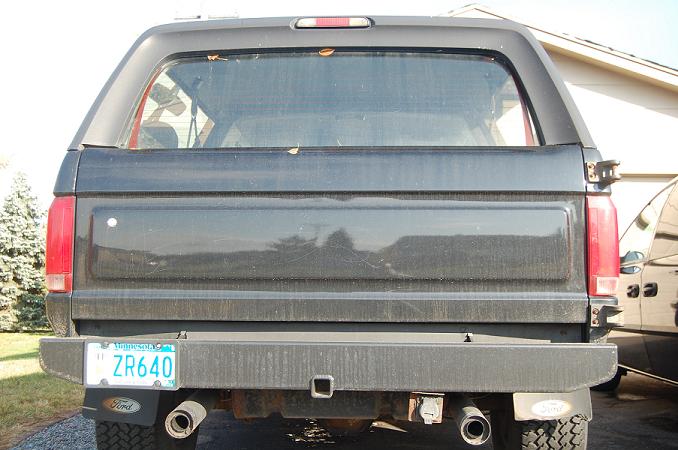 Rear view of a dark Ford Bronco SUV with Minnesota plate ZR640, dual exhaust and tow hitch