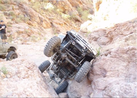 1986 Toyota Hilux - A vehicle is stuck on a steep, rocky incline, with another truck visible in the background.