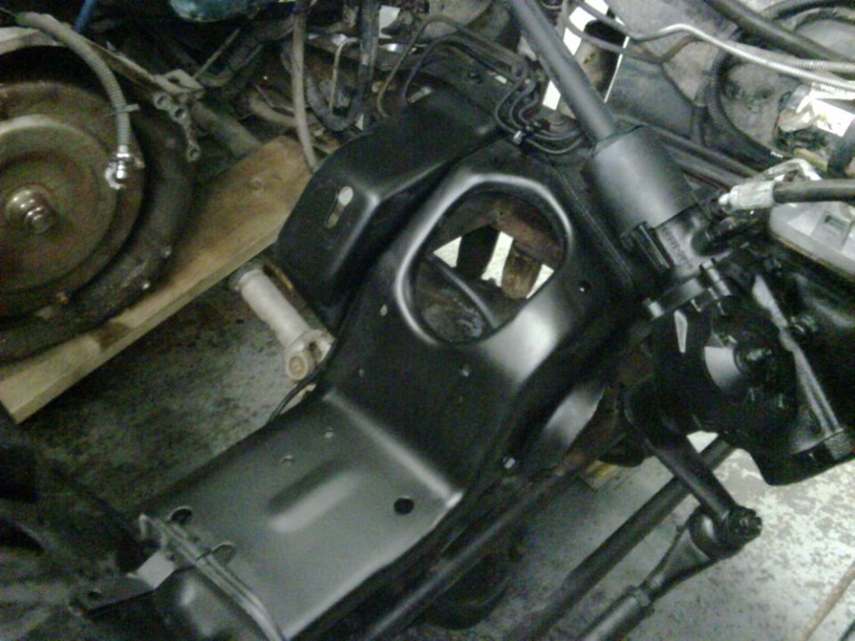 close-up of vehicle frame with steering parts and transmission bell housing