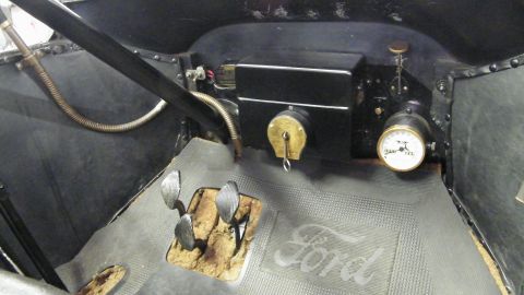 1915 Ford Model T - Close-up of a vintage Ford's interior, highlighting the dashboard controls and floor mat.
