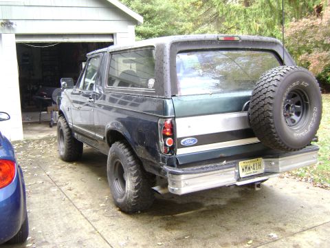 1994 Ford Bronco - This Ford Bronco is parked outside a garage with a spare tire mounted on the rear door.