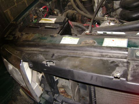1994 Ford Bronco - Engine bay of a 1994 Ford Bronco, the battery and various engine components.