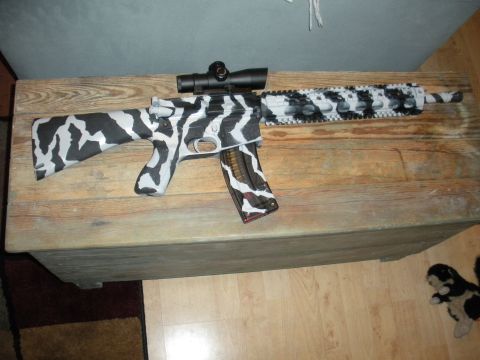 1996 Ford Bronco - A rifle with a unique black and white camouflage paint job is displayed on a wooden surface.