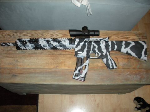 1996 Ford Bronco - A rifle with a distinctive black and white camouflage pattern is displayed on a wooden surface.