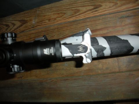 1996 Ford Bronco - Close-up of a rifle scope a camouflage pattern on its barrel.