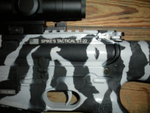 1996 Ford Bronco - Close-up of a rifle with a distinctive black and white camouflage pattern and visible tactical markings.