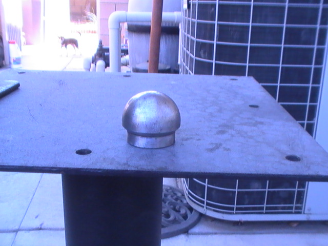 Metal cap on a flat surface with Supermotors logo at bottom right