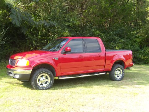 2007 Ford Mustang - This red Ford F-150 pickup truck is shown from the side, with trees and grass visible.