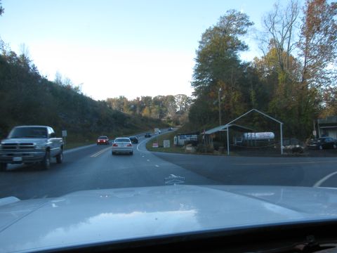 1985 Ford LTD Crown Victoria - Driving down a two-lane road with various vehicles and a roadside business.