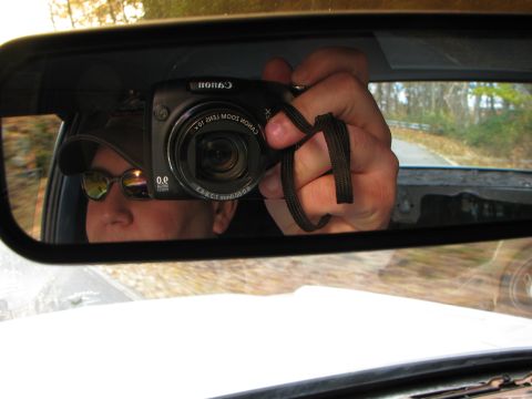 1985 Ford LTD Crown Victoria - Self-portrait in rearview mirror shows person holding a Canon camera while driving.