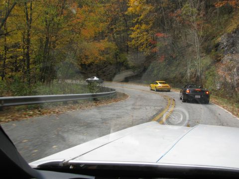 1985 Ford LTD Crown Victoria - A yellow Porsche and a black convertible navigate a scenic, winding road during the fall season.