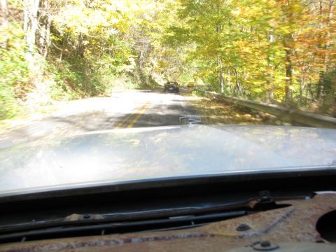 1985 Ford LTD Crown Victoria - Driving down a road surrounded by trees with yellow and orange leaves during the fall season.