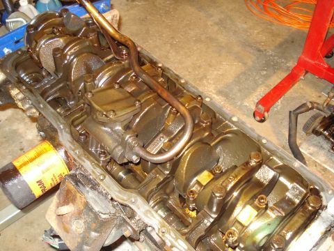1991 Ford Bronco - Close-up view of an engine's oil pan and internal components, including the crankshaft.