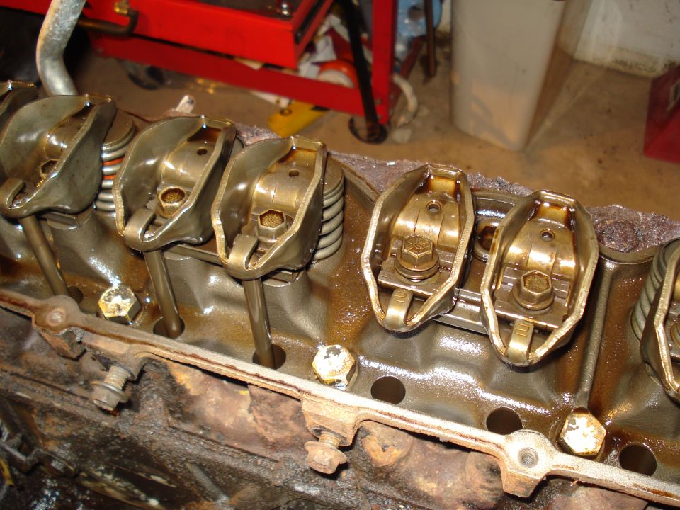Close-up of engine valve train components, including rocker arms and pushrods, in an engine block