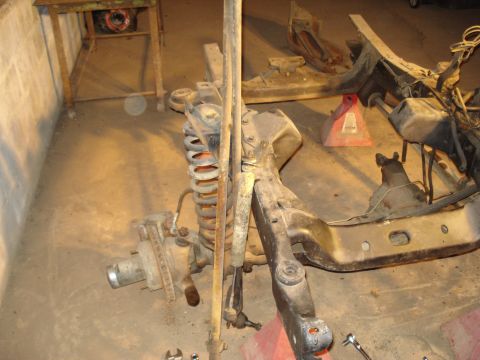 1991 Ford Bronco - Vehicle frame and suspension parts are disassembled and stored indoors.