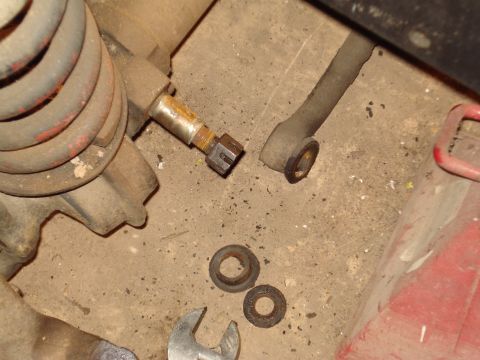 1991 Ford Bronco - Close-up view of vehicle suspension components and washers on a concrete surface.