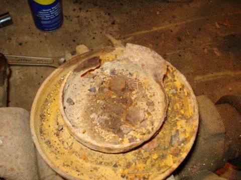 1991 Ford Bronco - A heavily corroded metal component, likely from a vehicle's drivetrain, shows significant rust and damage.