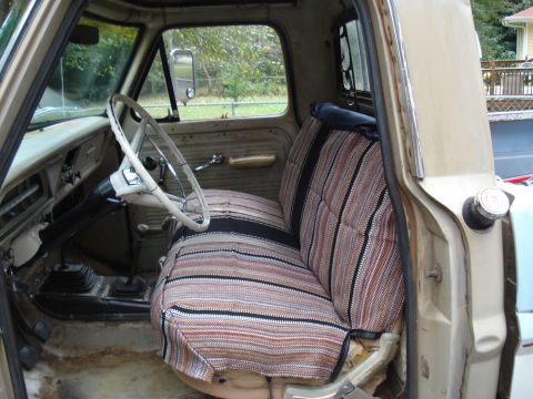 1967 Ford F-250 - The interior of a 1967 Ford F-250 shows its age with worn upholstery and a floor-mounted shifter.