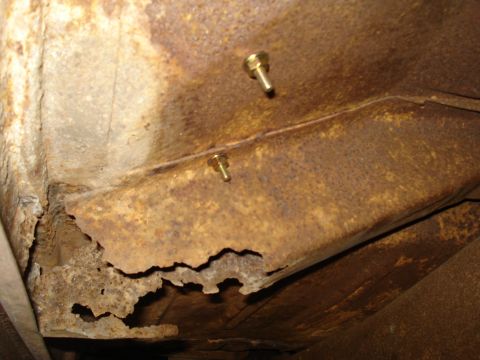 1967 Ford F-250 - Close-up of severely rusted metal frame, showing significant corrosion and two bolts.