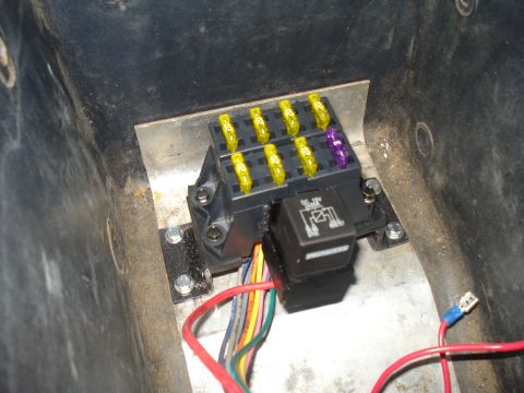 1984 Ford Bronco - Close-up of a vehicle's fuse box and relay, showing multiple fuses and wiring connections.