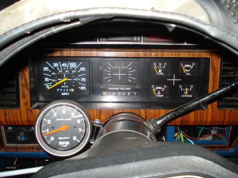 1984 Ford Bronco - Interior view of a 1984 Ford Bronco dashboard, the speedometer, fuel, oil, temperature, and charge gauges, plus an aftermarket tachometer.