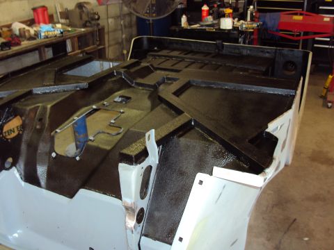 1948 Jeep Wrangler - The interior of a Jeep tub shows a black protective coating applied over its structural framework.