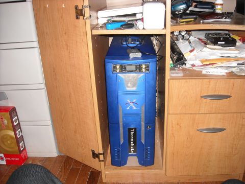 1979 Ford F-150 - A blue computer tower is stored inside a cabinet next to drawers and stacked containers.