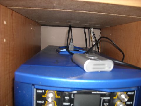 1979 Ford F-150 - Computer equipment with visible labels and wires is stored within a wooden cabinet.