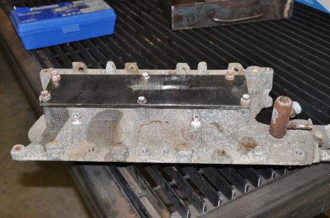 1996 Ford Bronco - A used engine intake manifold is shown, with a metal plate attached to its upper surface.