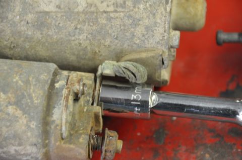 1996 Ford Bronco - A close-up view of a starter solenoid being worked on with a socket wrench.