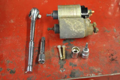 1996 Ford Bronco - Starter motors and assorted tools laid out on a red workbench surface.