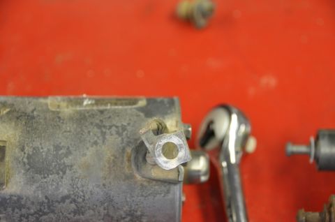 1996 Ford Bronco - A starter solenoid part is shown with a ratchet wrench and other small metal components on a red surface.