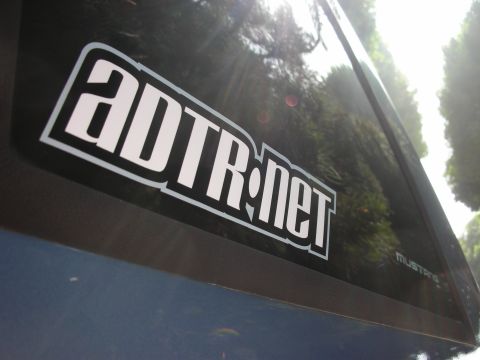 1990 Ford Mustang - A close-up view of a car's side window displays a prominent ADTR.net sticker and a subtle Mustang badge.