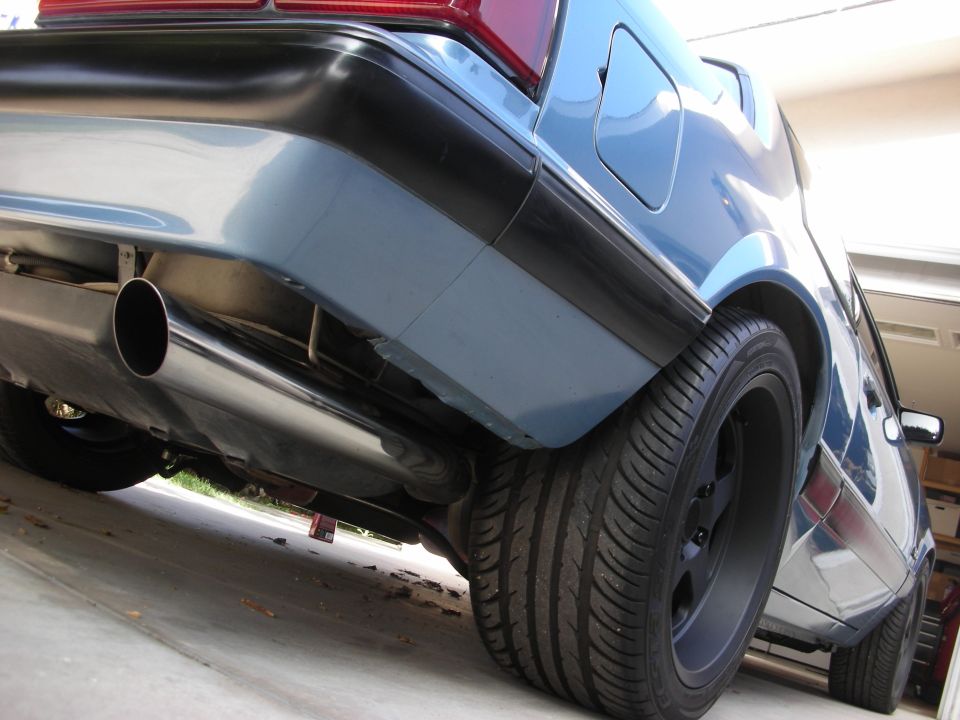 Blue car rear bumper and exhaust pipe, low angle view