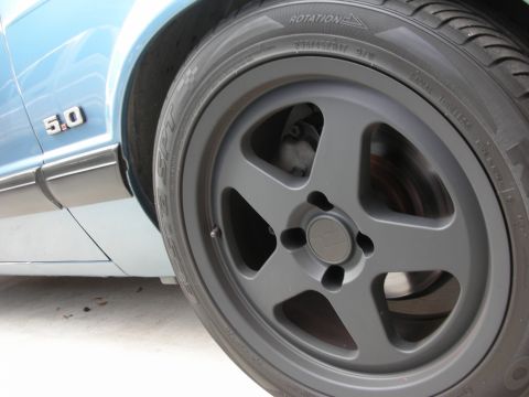 1990 Ford Mustang - Close-up of a 1990 Ford Mustang's side fender and wheel, the iconic 5.0 badge.