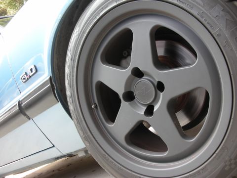 1990 Ford Mustang - Close-up of a 1990 Ford Mustang 5.0 fender badge and its wheel.