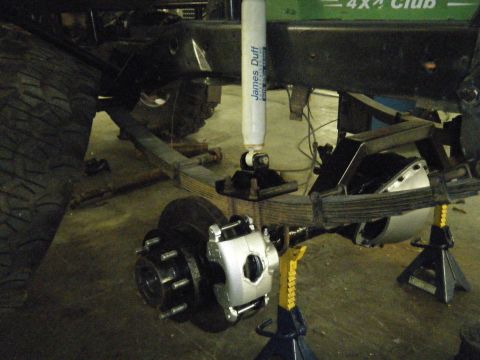 1978 Ford Bronco - Rear suspension of a 1978 Ford Bronco undergoing maintenance, with axle on jack stands.