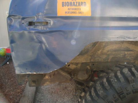 1979 Ford Bronco - Vehicle panel with biohazard sticker and visible damage. Tire and suspension components are also shown.