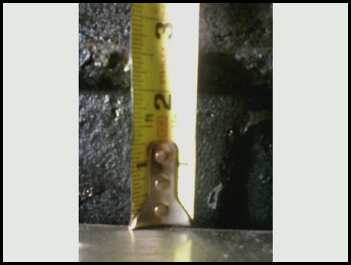 1996 Ford Bronco - A close-up of a measuring tape against a dark, textured surface, indicating inches.