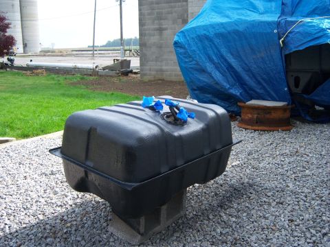 1996 Ford Bronco - A black fuel tank, likely for a Ford Bronco, sits on cinder blocks outdoors. The registry claims it is from a 1996 model.