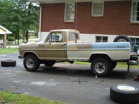 1967 Ford F-250 - Side view of a 1967 Ford F-250 pickup truck, appearing to be undergoing maintenance.